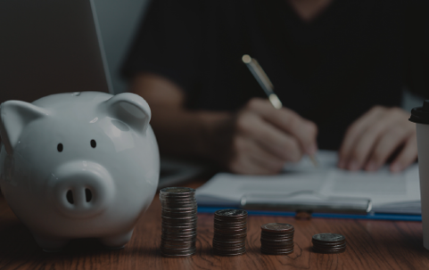 piggy bank & man writing on clipboard
